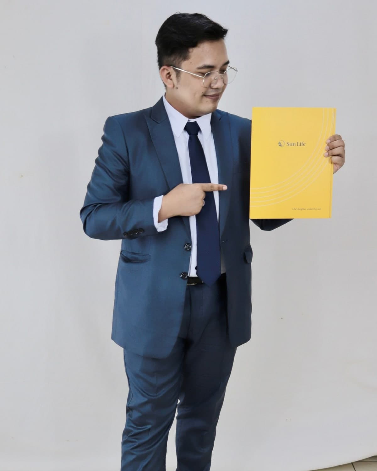 Rodel Hermogenes, licensed financial advisor with Sun Life, holding a Sun Life policy folder