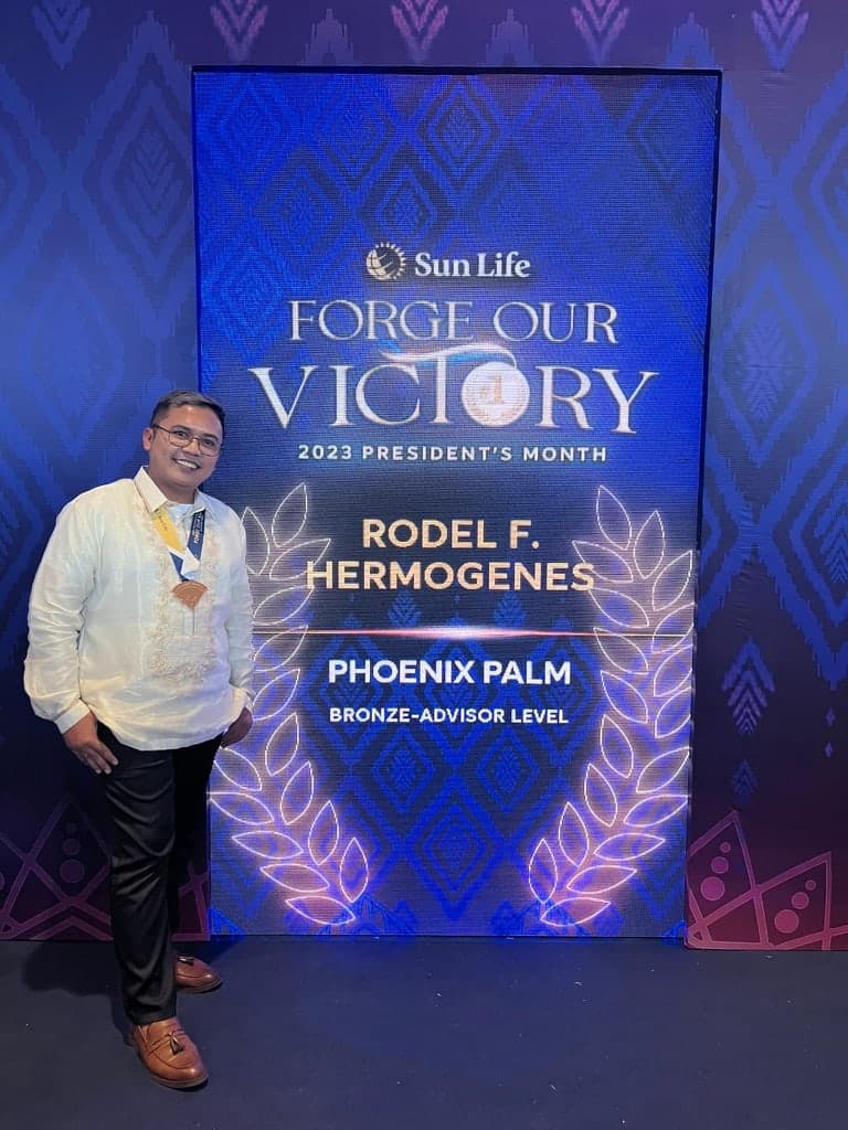 Rodel Hermogenes beside the Sun Life Forge Our Victory backdrop naming him a Bronze Advisor Level medallist
